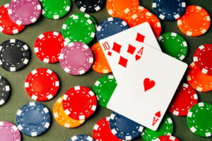 Playing cards and chips on green background close up